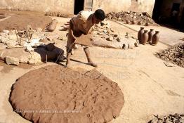 Image du Maroc Professionnelle de  Un ouvrier prend une parts d’argile pétrit, destinée au tourneur cette partie d’argile brut imprégnée d’eau se transformera en une forme d’objet grâce au savoir faire des artisans dans les ateliers de la Colline des Potiers à Safi, Vendredi 29 Août 1997. (Photo / Abdeljalil Bounhar) 